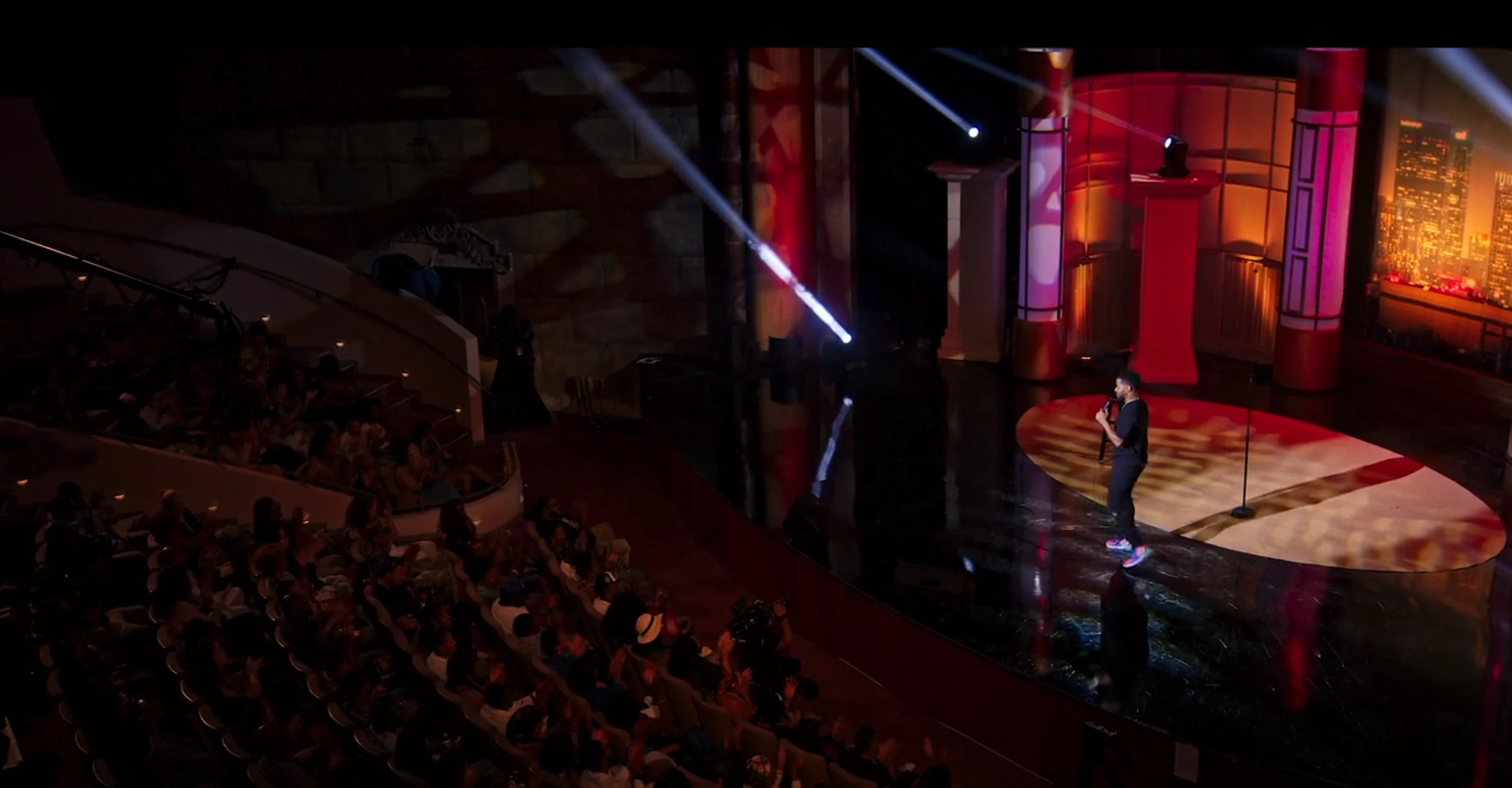 Ron G performing on a theater stage in front of a live audience